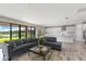 Spacious living room featuring a gray sofa and a large window with a lake view at 12821 Satin Lily Dr, Riverview, FL 33579