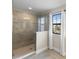 Bright tiled walk-in shower with glass door, tiled walls and a window offering natural light at 12821 Satin Lily Dr, Riverview, FL 33579