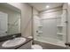 Bathroom features a tub with shower, a white sink, and a large mirror, providing a refreshing space at 14817 Summer Branch Dr, Lithia, FL 33547
