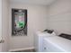 Functional laundry room with modern washer and dryer, utility shelf, and easy access to the home's mechanicals at 14817 Summer Branch Dr, Lithia, FL 33547