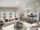 Bright open-plan living room features modern decor, stylish furniture, and seamless access to the kitchen and dining area at 14817 Summer Branch Dr, Lithia, FL 33547