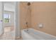 Bathroom featuring a tub and shower with neutral tiling and tile floors at 16102 Colchester Palms Dr, Tampa, FL 33647