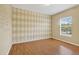 Bedroom featuring laminate flooring, a window, and decorative wall design at 16102 Colchester Palms Dr, Tampa, FL 33647