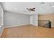 Large bonus room with wood-look floors, overlooking stairs, and a ceiling fan at 16102 Colchester Palms Dr, Tampa, FL 33647