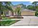 Charming two-story home with a three car garage, palm trees, and manicured lawn at 16102 Colchester Palms Dr, Tampa, FL 33647