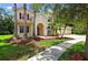 Inviting two-story home with manicured landscaping, a paver driveway, and a charming arched front entryway at 16102 Colchester Palms Dr, Tampa, FL 33647