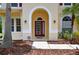 Charming front door with an arched entryway, decorative sidelights, and lush landscaping at 16102 Colchester Palms Dr, Tampa, FL 33647
