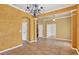 Open living room featuring neutral tile floors, decorative lighting, and access to the staircase and other rooms at 16102 Colchester Palms Dr, Tampa, FL 33647