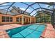 Sparkling pool inside screened enclosure, surrounded by brick patio, offers a relaxing outdoor oasis at 16102 Colchester Palms Dr, Tampa, FL 33647