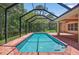 Clear pool with screened enclosure, adjacent to brick patio, perfect for outdoor relaxation and entertainment at 16102 Colchester Palms Dr, Tampa, FL 33647