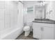 This bathroom features a sink with granite counters, a vanity with storage, and tub with shower at 1717 Preston S St, St Petersburg, FL 33712