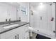 This bathroom features a sink with granite counters, a vanity with storage, and tiled shower at 1717 Preston S St, St Petersburg, FL 33712