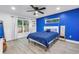 Bright bedroom featuring a blue accent wall, large windows, and modern decor at 1717 Preston S St, St Petersburg, FL 33712
