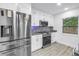 Updated kitchen features stainless steel appliances, white cabinets, and modern finishes at 1717 Preston S St, St Petersburg, FL 33712
