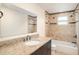 Bathroom features a vanity with granite countertop and dark cabinets and tiled tub with shower at 1741 Font Ln, Holiday, FL 34691