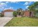 Charming single-Gathering home showcasing a well-manicured lawn and vibrant landscaping at 1741 Font Ln, Holiday, FL 34691