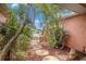 Front yard featuring stone stepping stones, mature landscaping, and flowering bushes at 1741 Font Ln, Holiday, FL 34691