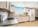 Bright kitchen with white cabinetry, modern appliances, and tiled countertops and backsplash at 1741 Font Ln, Holiday, FL 34691