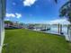 Spacious backyard with lush green grass leading to the waterfront and dock at 17715 Wall Cir, Redington Shores, FL 33708