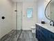 Modern bathroom featuring a walk-in shower and sleek navy blue vanity at 17715 Wall Cir, Redington Shores, FL 33708