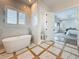 A luxurious bathroom with a soaking tub, walk-in shower, and elegant marble accents at 17715 Wall Cir, Redington Shores, FL 33708