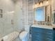 Elegant bathroom features a glass-enclosed shower, blue vanity with marble countertop, and stylish lighting at 17715 Wall Cir, Redington Shores, FL 33708
