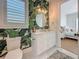 Modern bathroom with tropical wallpaper, a large round mirror, and a view to the bedroom at 17715 Wall Cir, Redington Shores, FL 33708