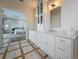 Bright bathroom featuring a dual sink vanity with white cabinets and marble countertops at 17715 Wall Cir, Redington Shores, FL 33708