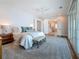 Bright bedroom with sitting bench, water views and large sliding glass doors to a balcony, and ceiling fan at 17715 Wall Cir, Redington Shores, FL 33708