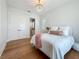 Bright bedroom features hardwood floors, a decorative chandelier, and direct access to an ensuite bathroom at 17715 Wall Cir, Redington Shores, FL 33708