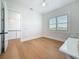 Bright bedroom with light wood floors, a view to a landing and a window with outside view at 17715 Wall Cir, Redington Shores, FL 33708