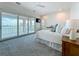 Bright bedroom with water views and large sliding glass doors to a balcony, light wood floors, and ceiling fan at 17715 Wall Cir, Redington Shores, FL 33708