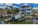 Beautiful waterfront home with a private boat dock and lift, complemented by lush tropical landscaping at 17715 Wall Cir, Redington Shores, FL 33708