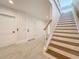 Bright foyer featuring shiplap walls, wood-accented stairs, and light tile flooring, creating a welcoming entrance at 17715 Wall Cir, Redington Shores, FL 33708