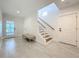 Elegant foyer with white shiplap walls, light tile flooring, and a staircase with modern metal railings at 17715 Wall Cir, Redington Shores, FL 33708