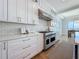 Bright kitchen featuring white cabinetry, stainless steel appliances, and a stylish herringbone backsplash at 17715 Wall Cir, Redington Shores, FL 33708