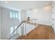Upstairs landing with modern railing, window with a view, and access to the bedrooms at 17715 Wall Cir, Redington Shores, FL 33708
