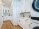 Spacious laundry room with white cabinets, quartz countertop, herringbone tile, and high-end washer/dryer at 17715 Wall Cir, Redington Shores, FL 33708