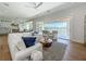 Spacious living room with lots of seating, a kitchen view, and balcony access at 17715 Wall Cir, Redington Shores, FL 33708