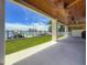 Covered patio with ceiling fans overlooking a grassy yard and boat dock at 17715 Wall Cir, Redington Shores, FL 33708