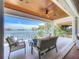 Relaxing covered patio overlooking serene waterfront view, with comfortable seating and ceiling fan at 17715 Wall Cir, Redington Shores, FL 33708