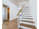 Bright open staircase with hardwood floors, modern railing design, and access to a bathroom at 17715 Wall Cir, Redington Shores, FL 33708