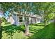 Lush backyard featuring a screened patio, well-maintained lawn, and mature trees at 2120 Gwynhurst Blvd, Wesley Chapel, FL 33543