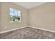 Comfortable bedroom with soft carpet, natural light from the large window, and neutral color palette at 2120 Gwynhurst Blvd, Wesley Chapel, FL 33543