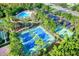 Aerial view of community amenities featuring a pool, parking area, tennis courts, and playground at 2120 Gwynhurst Blvd, Wesley Chapel, FL 33543