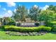 The Windsor community entrance boasts a stone sign with manicured landscaping and blooming flowers at 2120 Gwynhurst Blvd, Wesley Chapel, FL 33543