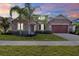 Beautiful single-story home featuring stone accents, a manicured lawn, and a two-car garage at 2120 Gwynhurst Blvd, Wesley Chapel, FL 33543