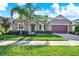 Beautiful single-story home featuring stone accents, a manicured lawn, and a two-car garage at 2120 Gwynhurst Blvd, Wesley Chapel, FL 33543