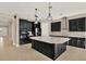 Elegant kitchen with black cabinets, a large island with light countertops, and brick backsplash at 2120 Gwynhurst Blvd, Wesley Chapel, FL 33543