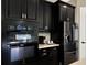 Gourmet kitchen features a stainless steel refrigerator, built-in microwave and dark cabinetry at 2120 Gwynhurst Blvd, Wesley Chapel, FL 33543